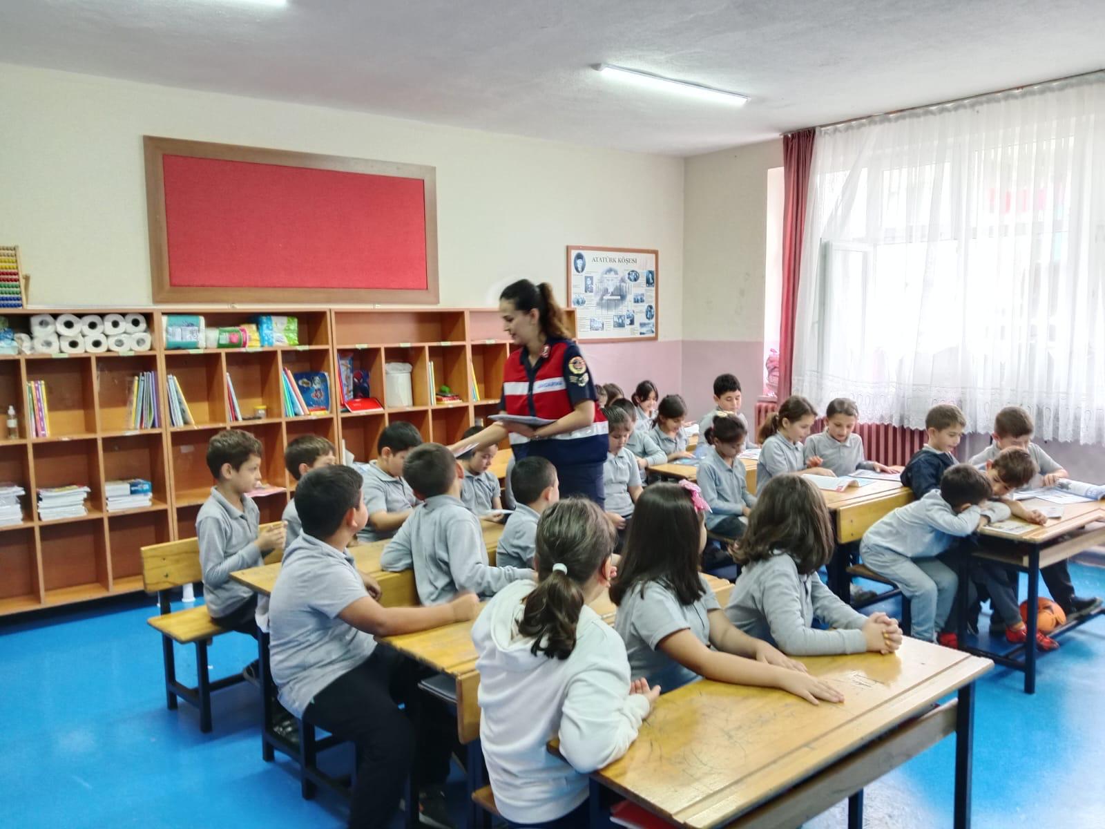 a woman standing in a classroom with a group of kids